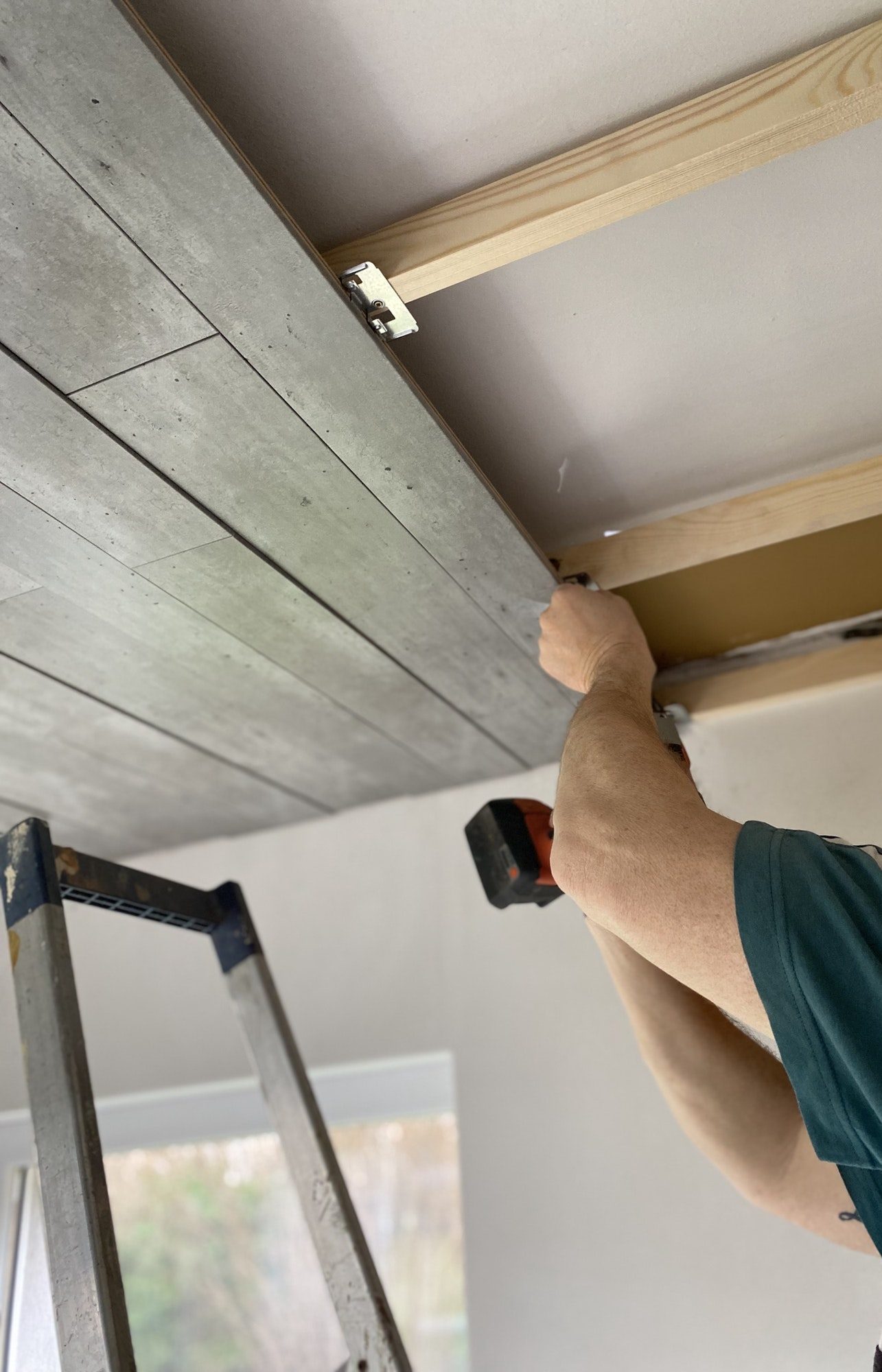 Man attaching a new ceiling during his home renovations